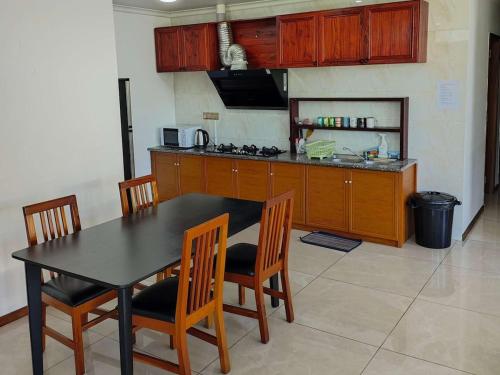 a kitchen with a black table and chairs and a counter at Alice 3-bedroom luxury apartment in Nadi