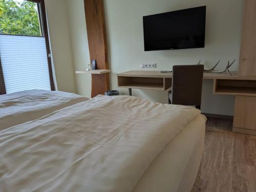 a bedroom with a bed and a desk with a television at Jagdhaus Rech - Ahr in Rech