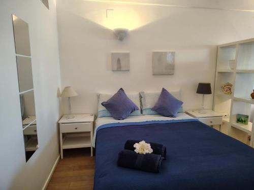 a bedroom with a blue bed with purple pillows at Casa vista Faraglioni Capri in Capri