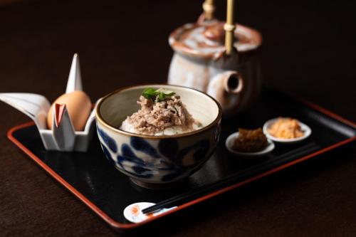 une assiette avec un bol de nourriture sur une table dans l'établissement Samsara Inn 今だけオープン特別価格, à Tanabe