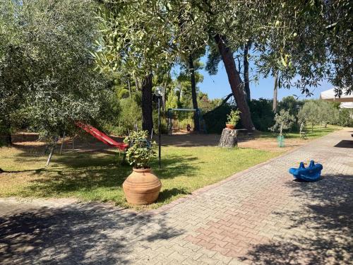 a park with a playground with a swing at Lagomandra Nakis in Lagomandra