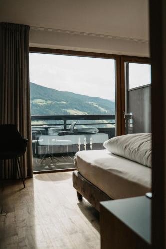 ein Schlafzimmer mit Blick auf eine Badewanne und ein Bett in der Unterkunft Hotel Lahnerhof in Sterzing