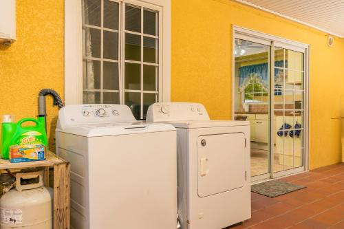 two washing machines sitting outside of a yellow house at Casa de Reyes in Palm-Eagle Beach