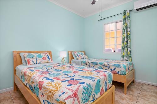 a bedroom with two beds and a window at Casa de Reyes in Palm-Eagle Beach