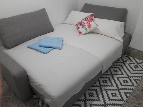a white bed with two pillows and two towels on it at A beautiful Townhouse in Rute