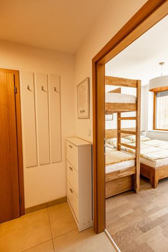 a bedroom with two bunk beds and a mirror at Apartmán Čihadla in Bedřichov