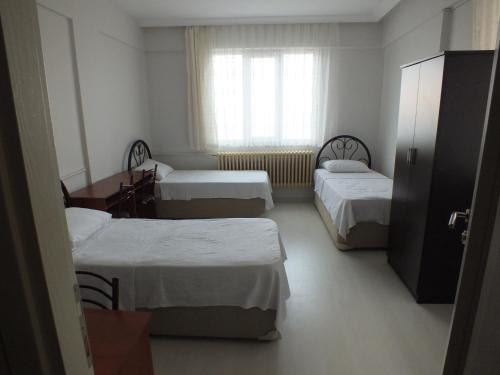 チャイェリにあるSengul Apartのベッド3台と窓が備わる客室です。