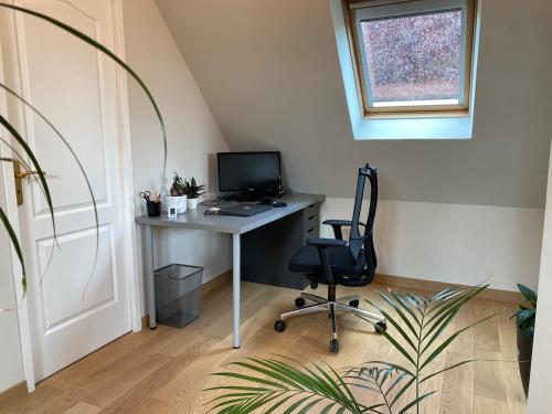 an office with a desk with a computer and a chair at Quite House in Villiers-le-Morhier