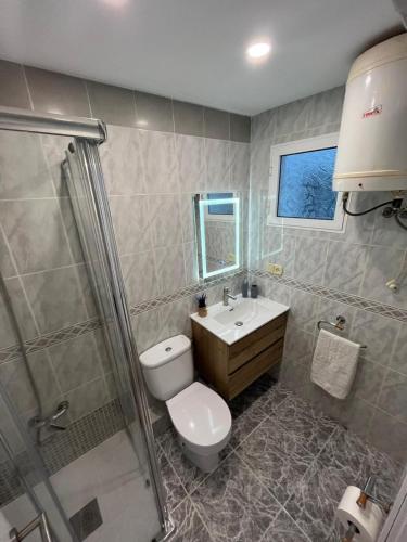 a bathroom with a toilet and a sink and a shower at De frente al mar in Sueca
