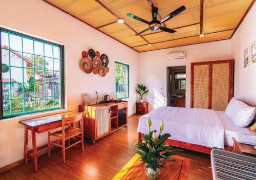 ein Schlafzimmer mit einem Bett, einem Schreibtisch und einem Tisch in der Unterkunft Tropical Rustic 4BR Villa, South Phu Quoc in Phu Quoc