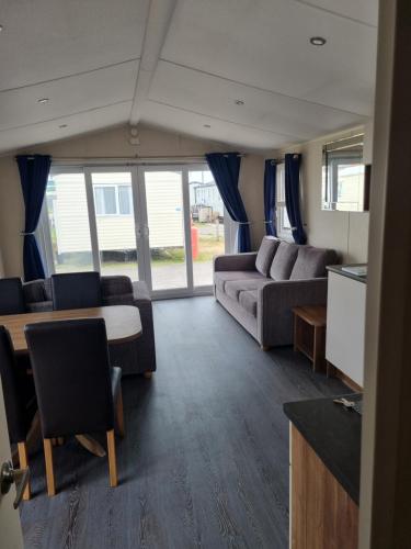 a living room with a couch and a table at Newton Beach retreat in Porthcawl