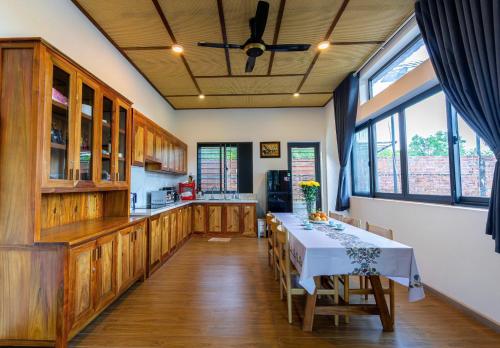 eine Küche mit einem Tisch mit einer weißen Tischdecke in der Unterkunft Tropical Rustic 4BR Villa, South Phu Quoc in Phu Quoc