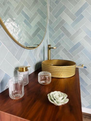 a bathroom with a wooden table with glasses and a sink at Casas da Pereira in Barcos