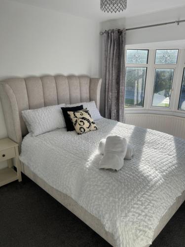 a white bed with two towels on top of it at Coastal Corporate Stays in Blythe