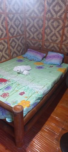 a bed with pillows on it in a room at Dumaguete Divers in Dauin