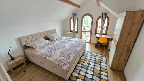 Un dormitorio con una cama con alfombra y dos ventanas. en Dom Hlohovec Center, en Hlohovec