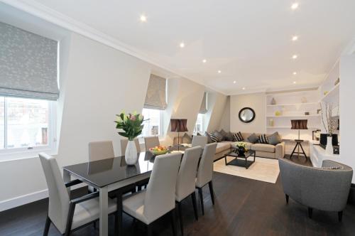 a dining room and living room with a table and chairs at 20 Hertford Street - Mayfair Apartments in London