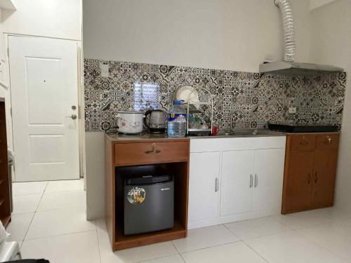 a kitchen with a sink and a stove in it at JLC Crib in Naga