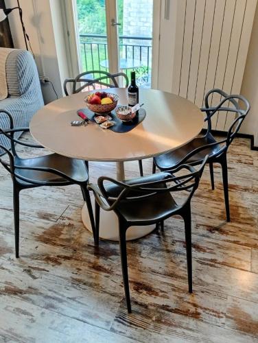 a table with chairs and a bowl of fruit on it at La petite maison de Claire in Cuneo