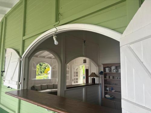 ラ・トリニテにあるLa Maison Verteの緑の壁にアーチ型の通路があるキッチン