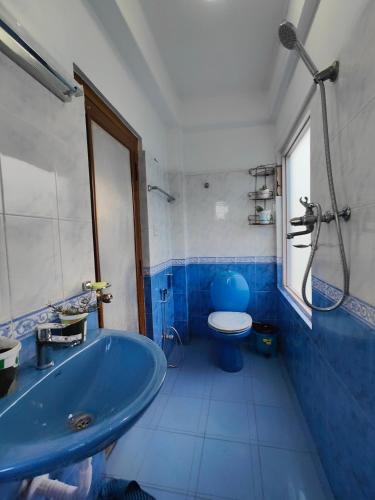 a bathroom with a blue tub and a toilet at Peace Home Apartment Swayambhu in Kathmandu