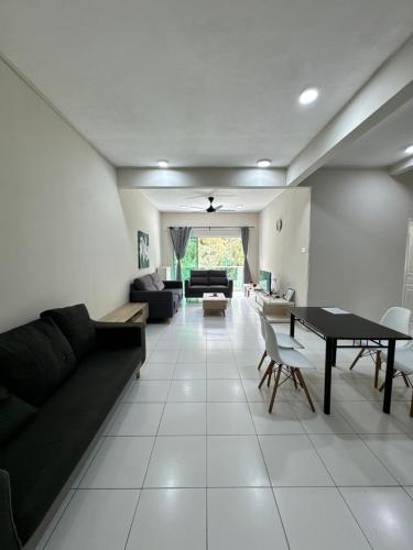 a living room with a black couch and a table at Ayaan Quintet Evergreen with FIFA & Private Parking in Tanah Rata