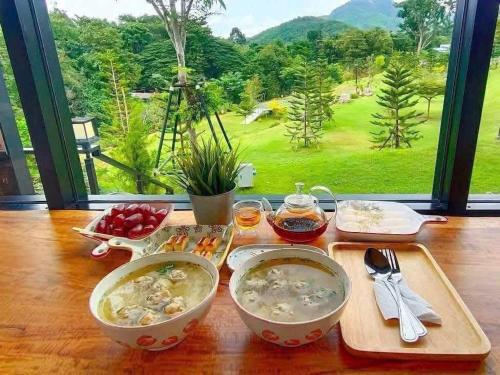 Una mesa con tres cuencos de comida y una ventana. en PhuMan Resort & Cafe Phetchaburi, en Ban Wang Malako