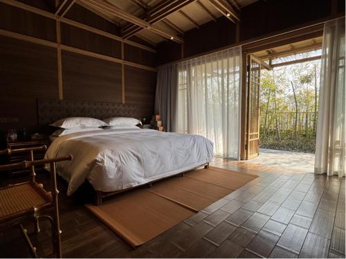 a bedroom with a large bed and a large window at 杭州西湖茶荟酒店 G hotel west lake hotel in Hangzhou