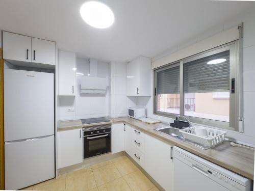 a kitchen with white cabinets and a sink and a window at Apartamento San Diego 1 - Almyra Inmobiliaria in Los Alcázares