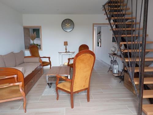 a living room with a table and chairs and a couch at Le petit charme in Melay