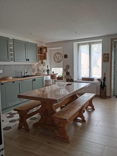 a kitchen with a large wooden table and benches at Le petit charme in Melay