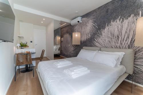 a bedroom with a white bed with a wall mural at Pico Apartments - Roma 20 in Sanremo