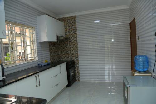 a kitchen with white cabinets and a large window at SixPoint Victoria in Kisumu