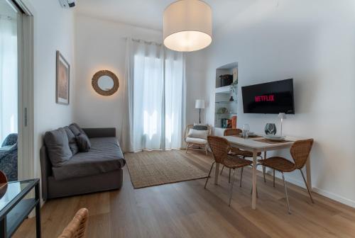 a living room with a couch and a table and chairs at Pico Apartments - Roma 20 in Sanremo