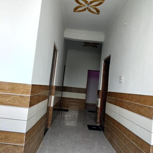 a hallway with wood and white walls and a ceiling at SHREE MANDAP HOTEl 