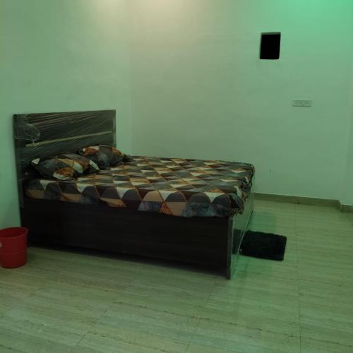 a bed in a white room with a bed frame at SHREE MANDAP HOTEl 