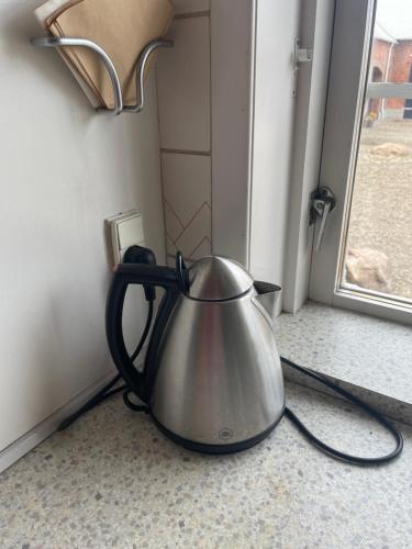 a tea kettle sitting on the floor next to a door at Vestergård B&B in Varde