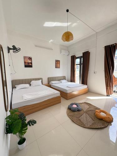 a bedroom with two beds and a rug at Kim Phung Homestay in Dong Hoi