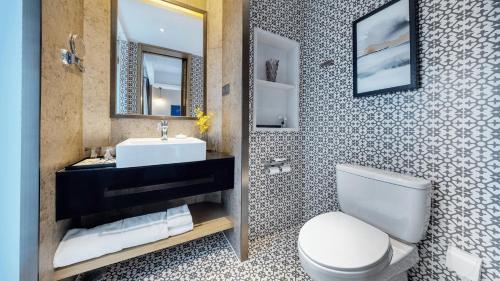 a bathroom with a toilet and a sink and a mirror at MuYun Villa Lijiang in Lijiang
