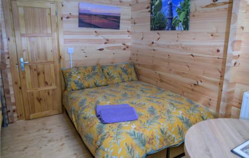 a small bed in a room with a wooden wall at Snowdrop Cabin Retreat dog friendly peaceful in Huttoft