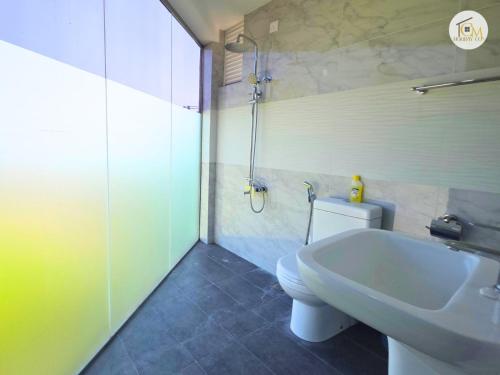 Un baño con un inodoro blanco y un lavabo. en Hikka Ocean View by CM Holiday, en Hikkaduwa