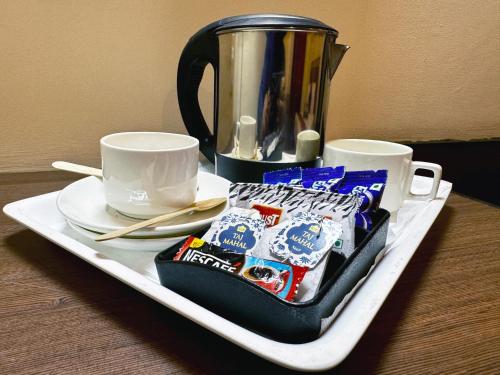una bandeja con bolsitas de té y tazas sobre una mesa en Sarovar Regency, en Amritsar