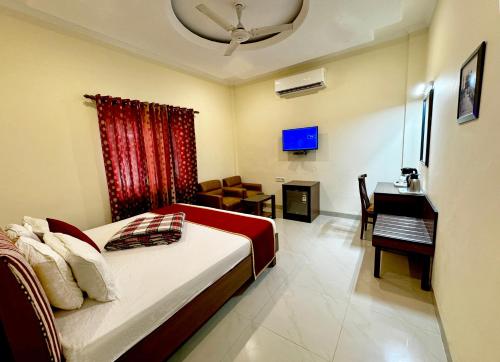 una camera da letto con un letto e una scrivania in una stanza di Sarovar Regency ad Amritsar