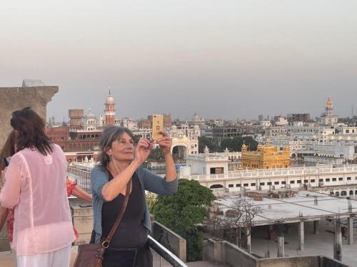 una mujer tomando una fotografía de una ciudad en Sarovar Regency, en Amritsar