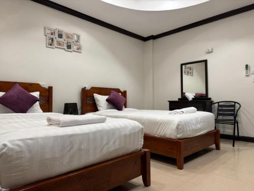 a bedroom with two beds and a mirror at SVAH Boutique Patong in Patong Beach