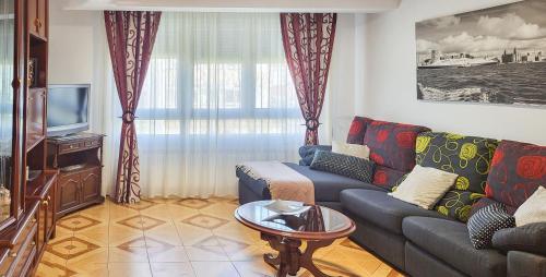 a living room with a couch and a tv at AG Piso Isabema a 400m del centro de Carballo in Carballo