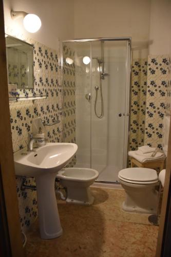 Un baño con inodoro, lavabo y ducha. en Villa Ca' Conti, en Granze