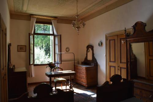 Habitación con mesa, espejo y ventana en Villa Ca' Conti, en Granze