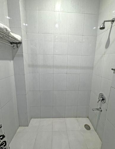 ein weißes Badezimmer mit Dusche und Abfluss in der Unterkunft Sarovar Regency in Amritsar