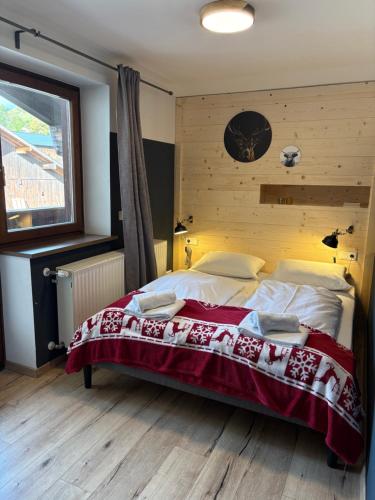 a bedroom with a bed and a clock on the wall at Apartments Chalet Sonnentanz in Piesendorf